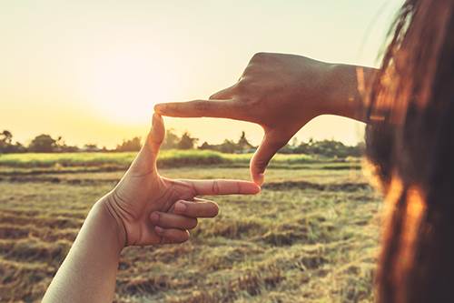 Woman using fingers to view open land